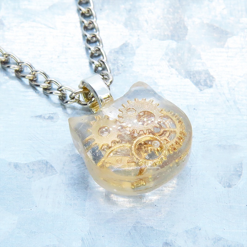 猫フェイスチャーム スチームパンク風 ゴールドカラーの歯車を封入したクリアレジンチャームネックレス 長さ調整可 アジャスター可