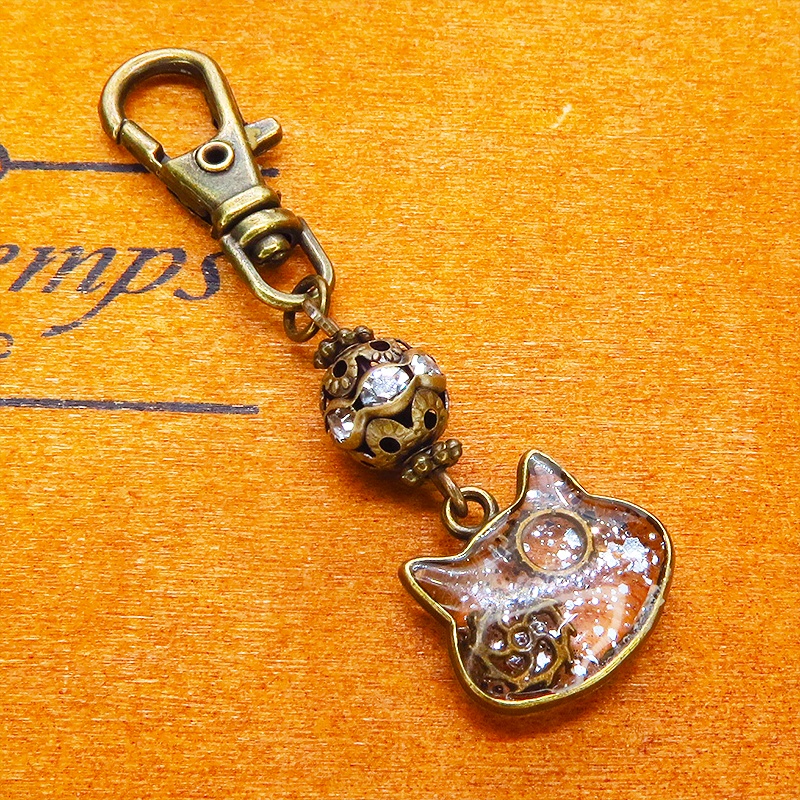 アンティークゴールド 猫フェイスに歯車を封入した可愛いキーホルダー レジン スチームパンク風 金具変更可
