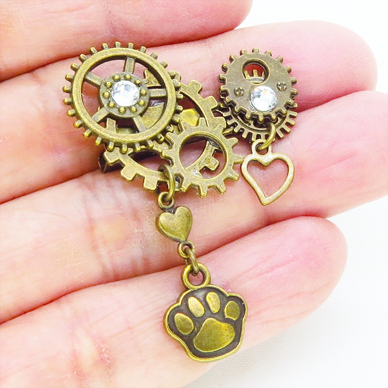 アンティークゴールド 肉球と歯車を組合せたスチームパンク風のコンパクトなブローチ バッジ ラインストーン 猫 犬