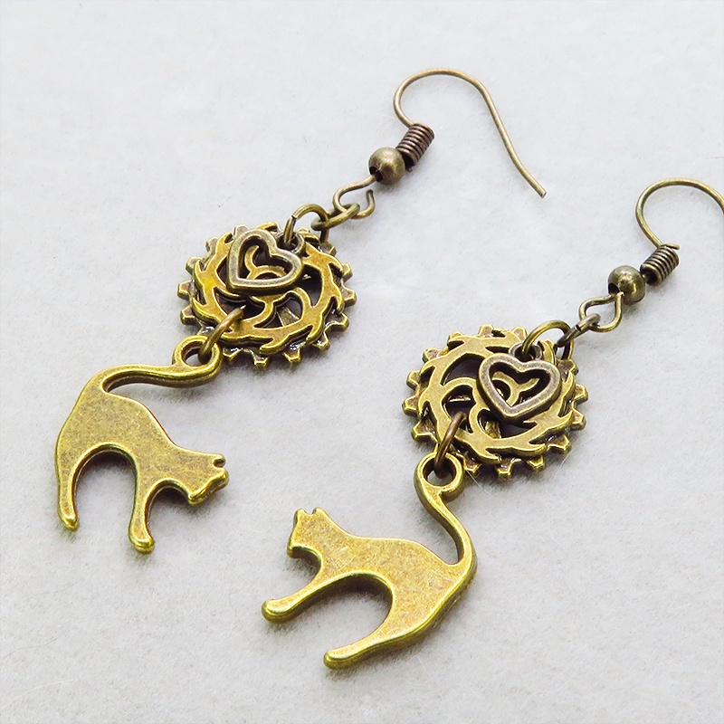 アンティークゴールド 跳ね猫と歯車を組合せたスチームパンク風のコンパクトなピアス ハート