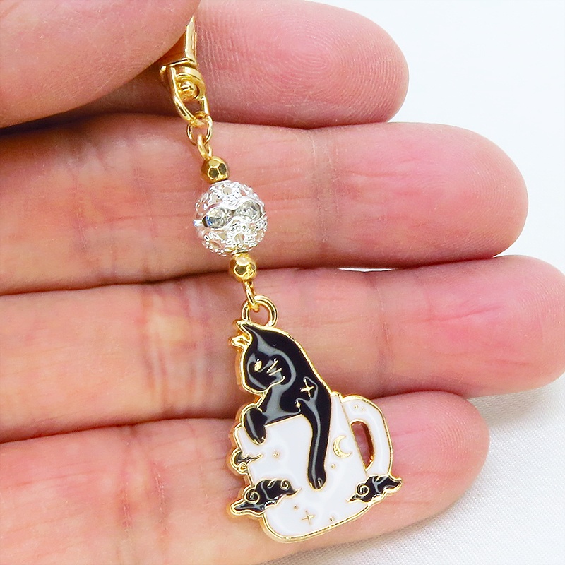 白いマグカップでくつろぐ黒猫チャームのキーホルダー シルバー・ブラックメタルビーズ 金具変更可
