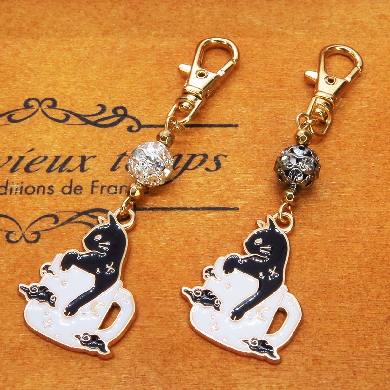 白いマグカップでくつろぐ黒猫チャームのキーホルダー シルバー・ブラックメタルビーズ 金具変更可