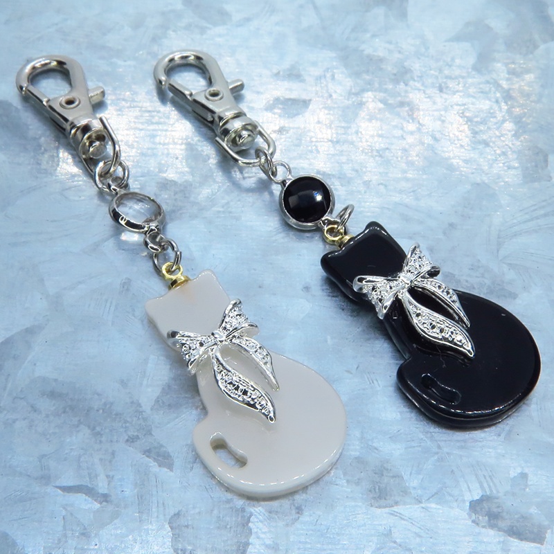シルバーカラーリボン付きの猫シルエットモチーフとラインストーンのキーホルダー 白黒色選択 金具変更可