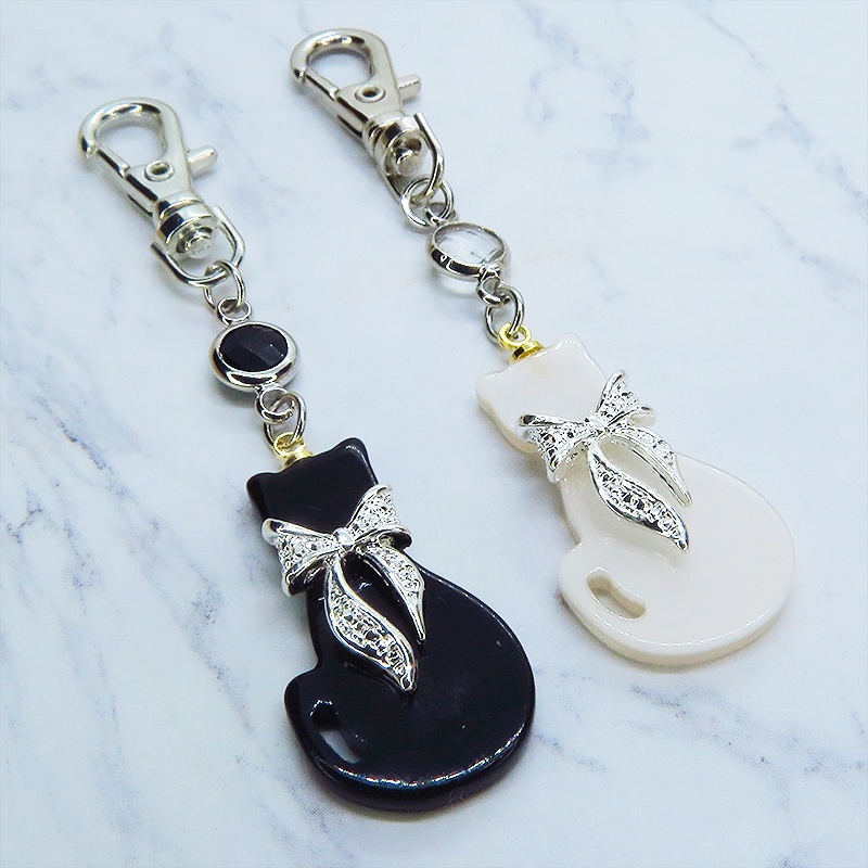 シルバーカラーリボン付きの猫シルエットモチーフとラインストーンのキーホルダー 白黒色選択 金具変更可
