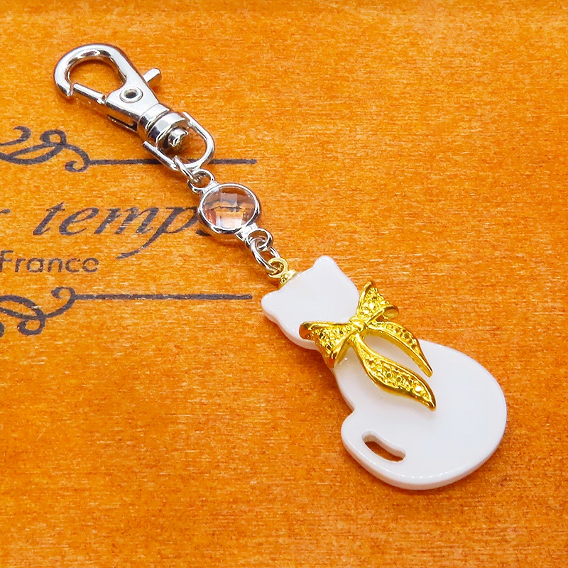 ゴールドカラーリボン付きの白猫シルエットモチーフとラインストーンのキーホルダー 金具変更可