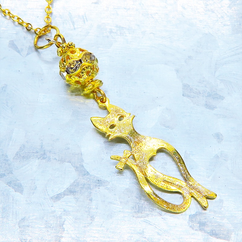 ラメ入りゴールドカラーのスマートな猫シルエットモチーフとメタルビーズのペンダントネックレス 長さ調整可