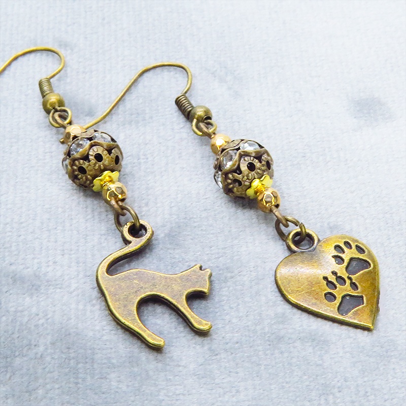 アンティークゴールド 跳ね猫と肉球ハートと組合せたアシンメトリーピアス メタルビーズ ラインストーン