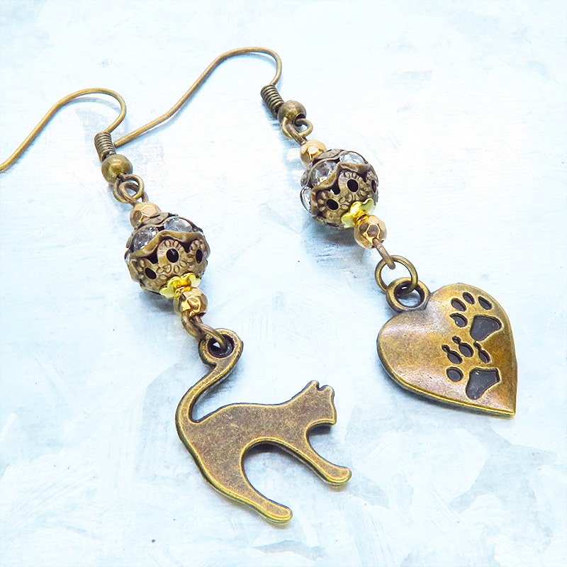 アンティークゴールド 跳ね猫と肉球ハートと組合せたアシンメトリーピアス メタルビーズ ラインストーン