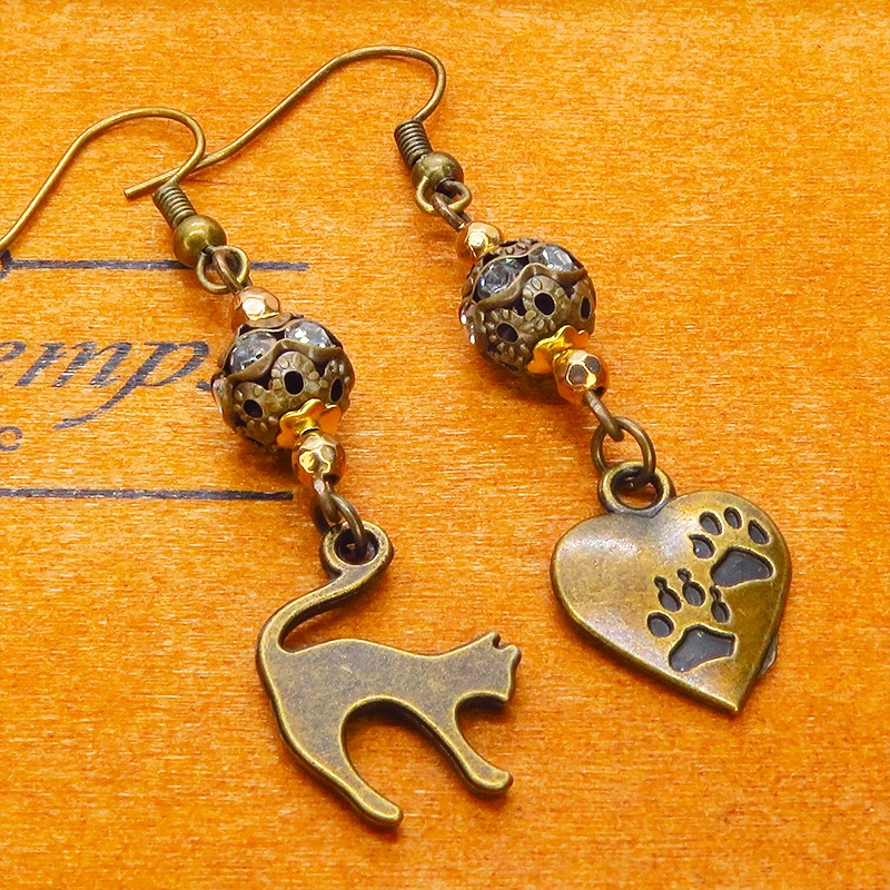 アンティークゴールド 跳ね猫と肉球ハートと組合せたアシンメトリーピアス メタルビーズ ラインストーン