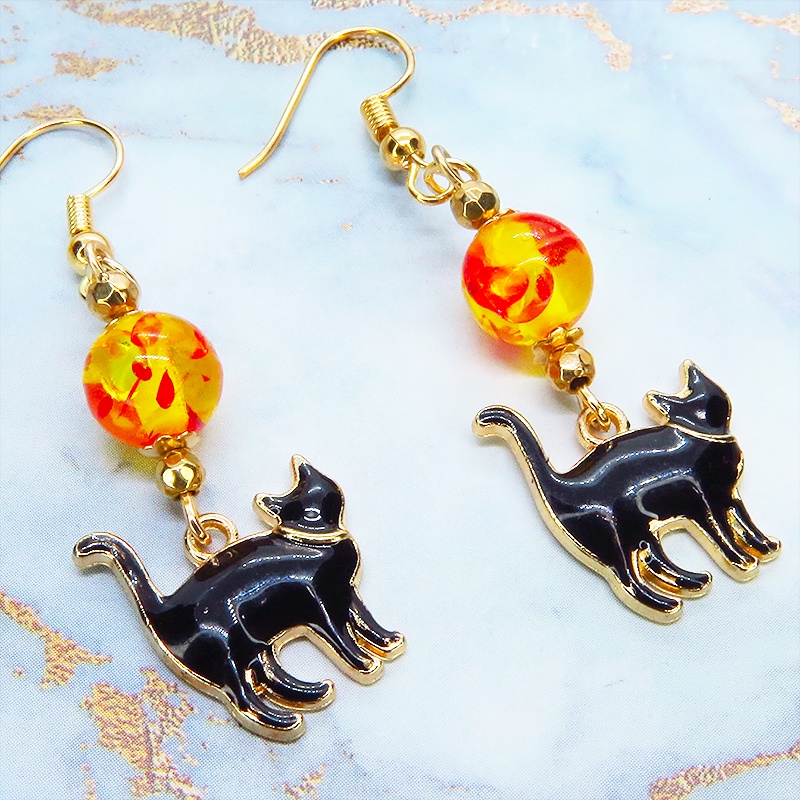 歩き黒猫シルエットモチーフとオレンジイエロークリアビーズの大人可愛いピアス マットゴールド エナメル サージカル可