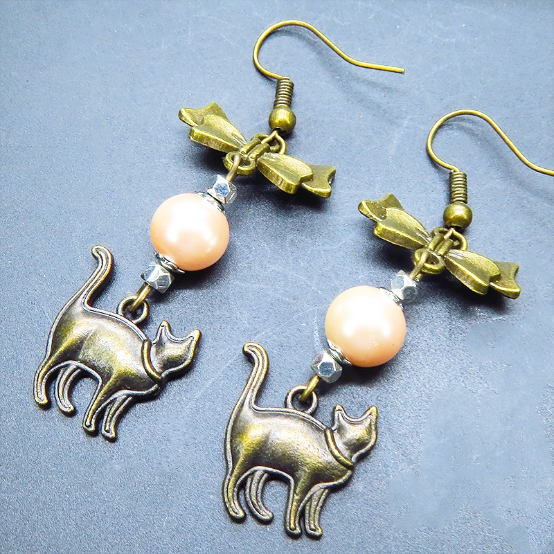 アンティークゴールド 歩き猫とリボンにベージュカラーのビーズを組合せた大人可愛いピアス サージカル可