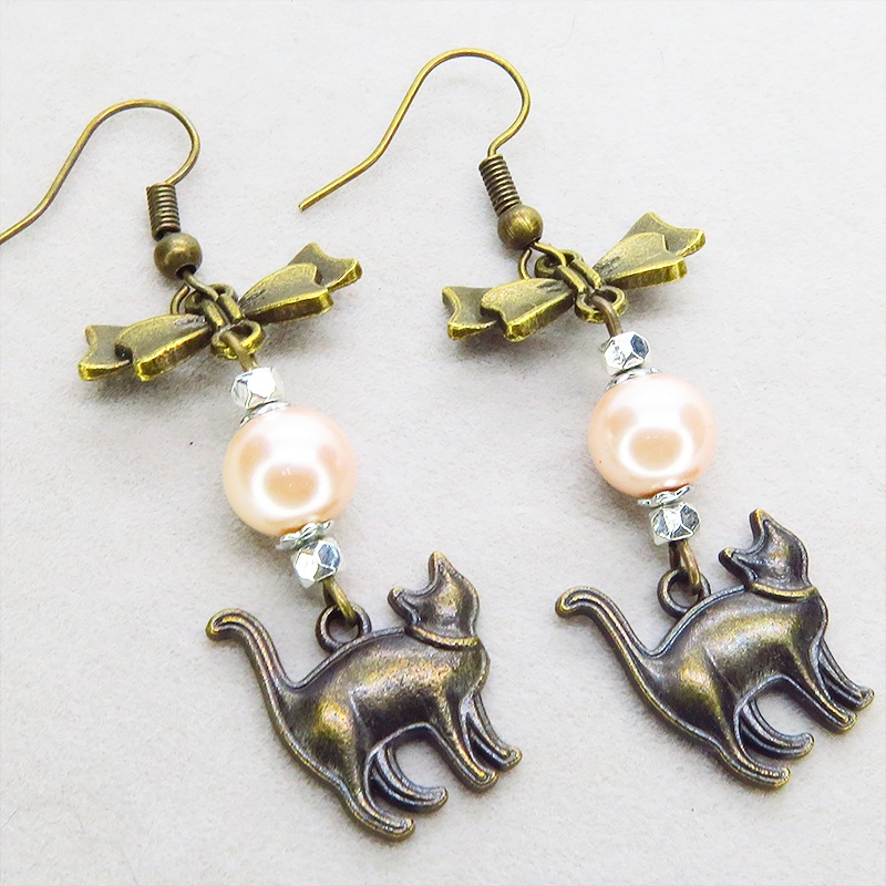 アンティークゴールド 歩き猫とリボンにベージュカラーのビーズを組合せた大人可愛いピアス サージカル可