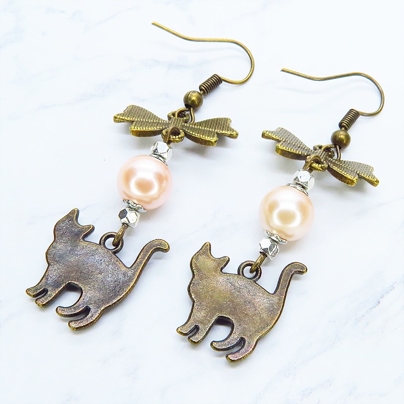 アンティークゴールド 歩き猫とリボンにベージュカラーのビーズを組合せた大人可愛いピアス サージカル可