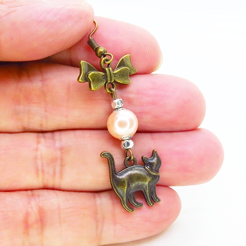 アンティークゴールド 歩き猫とリボンにベージュカラーのビーズを組合せた大人可愛いピアス サージカル可