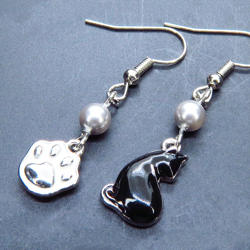 シルバーカラー 振り向き黒猫と肉球のアシンメトリーピアス スワロフスキーパール(シルバーグレー) サージカル可