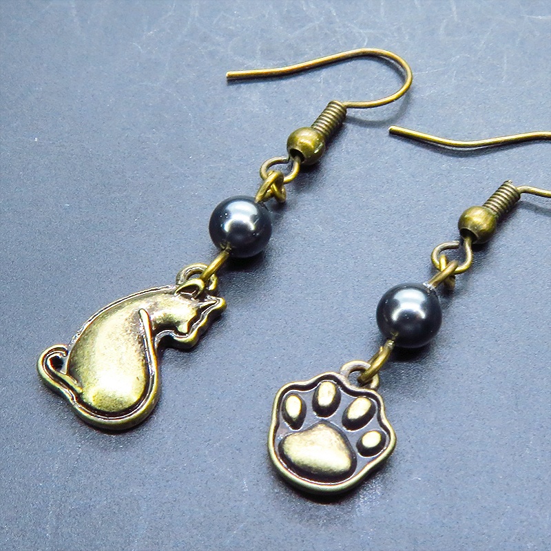 アンティークゴールド 振り向き猫と肉球のアシンメトリーピアス スワロフスキーパール(ブラック)