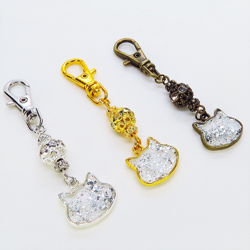 シルバーカラー 猫フェイスモチーフのクリアカラーレジンのキーホルダー ラインストーン入りメタルビーズ 金具変更可