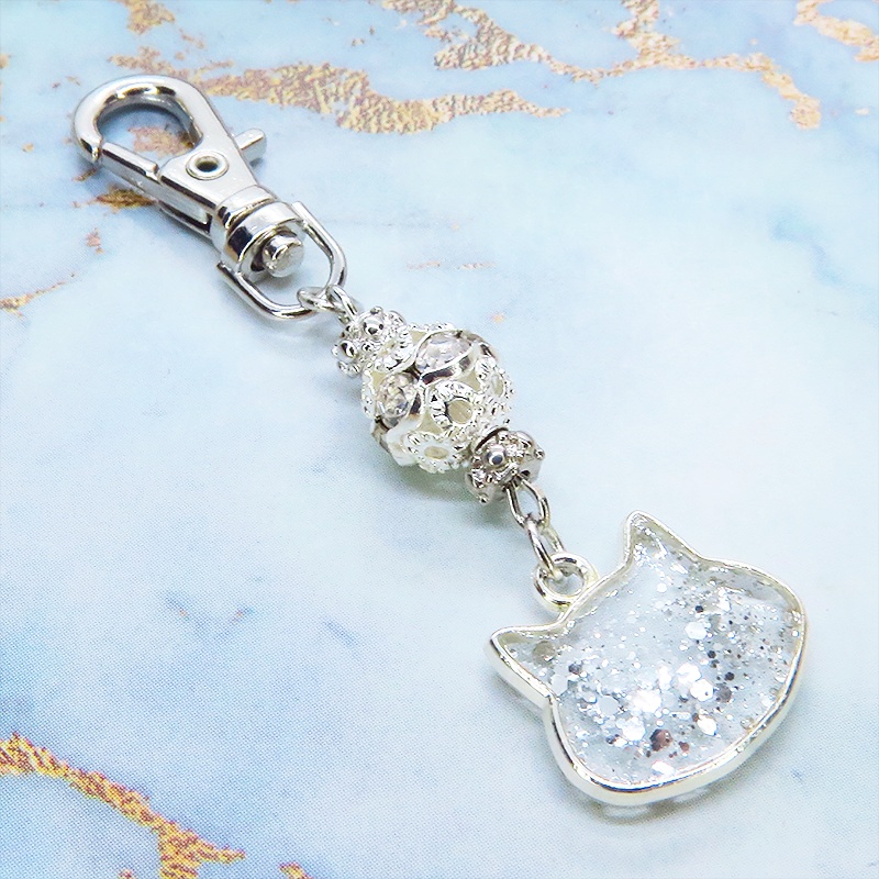 シルバーカラー 猫フェイスモチーフのクリアカラーレジンのキーホルダー ラインストーン入りメタルビーズ 金具変更可