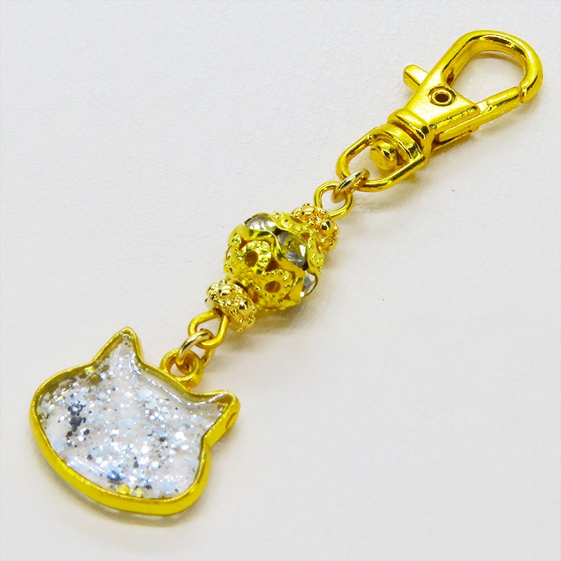 ゴールドカラー 猫フェイスモチーフのクリアカラーレジンのキーホルダー ラインストーン入りメタルビーズ 金具変更可