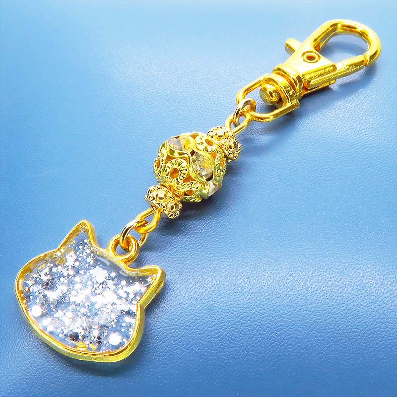 ゴールドカラー 猫フェイスモチーフのクリアカラーレジンのキーホルダー ラインストーン入りメタルビーズ 金具変更可