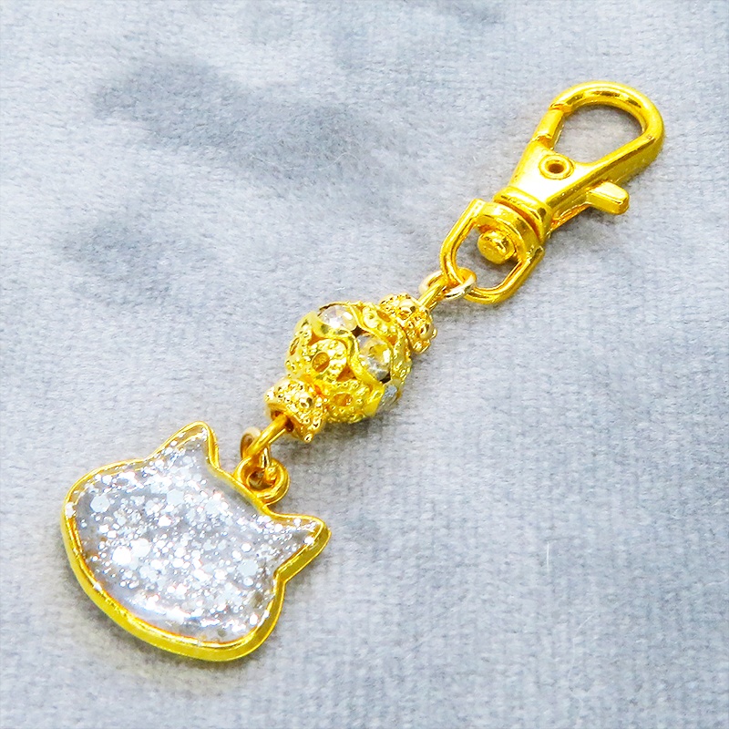 ゴールドカラー 猫フェイスモチーフのクリアカラーレジンのキーホルダー ラインストーン入りメタルビーズ 金具変更可