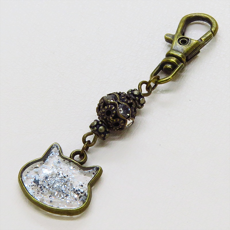 アンティークゴールド 猫フェイスモチーフのクリアカラーレジンのキーホルダー ラインストーン入りメタルビーズ 金具変更可