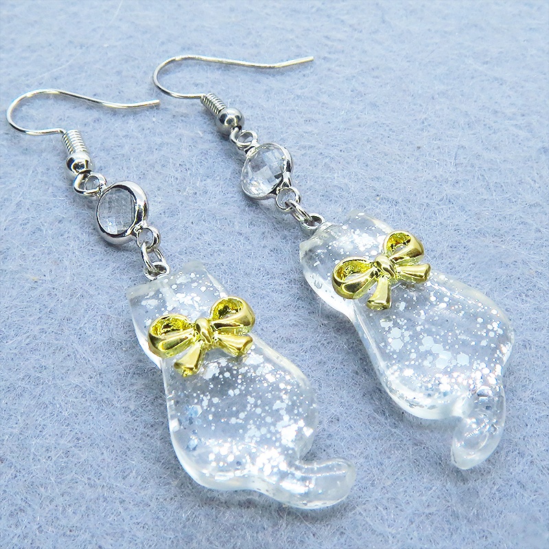 ゴールドカラーのリボンを付けたクリアカラーの猫シルエットモチーフのピアス ラインストーン サージカル可