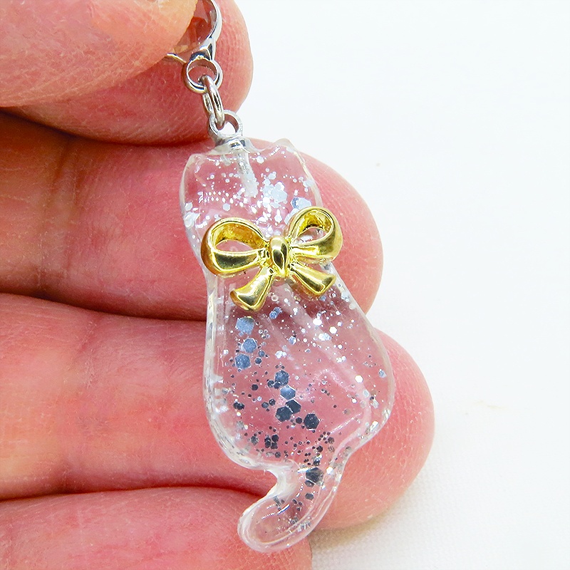 ゴールドカラーのリボンを付けたクリアカラーの猫シルエットモチーフのピアス ラインストーン サージカル可