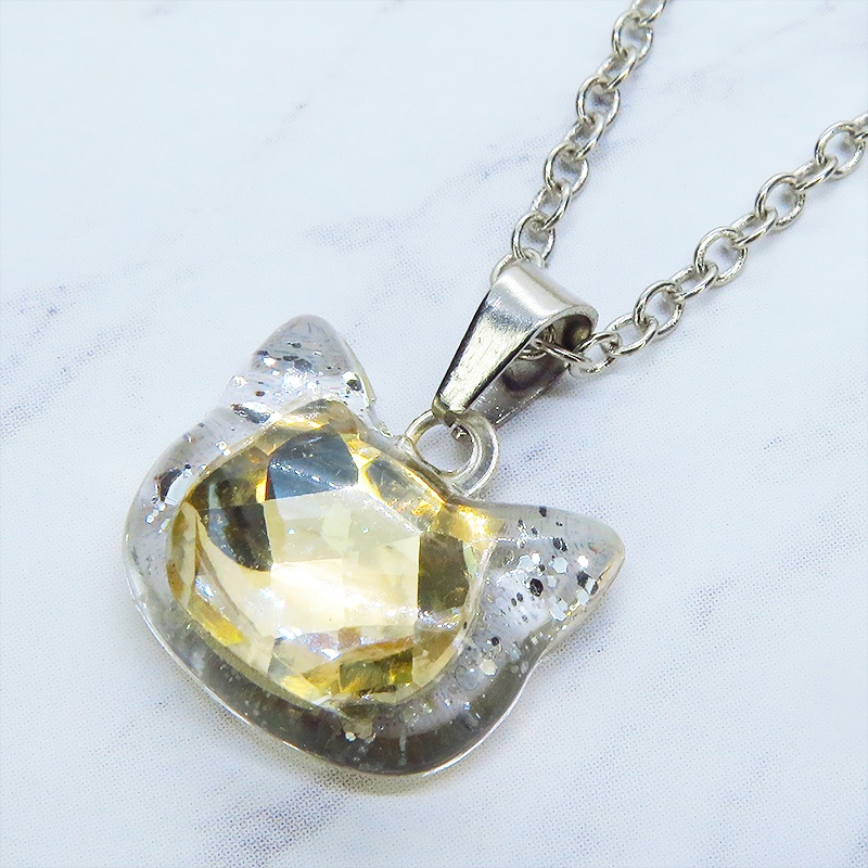 シルバーカラー 猫フェイスモチーフのシャンパンカラークリスタルのペンダントネックレス レジン 長さ調整可 ステンレス可