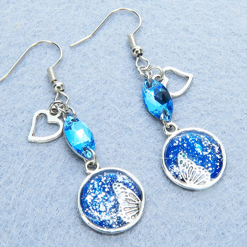 ブルーレジンで彩色した蝶の羽とアクアマリンのスワロフスキーのピアス オープンハート サージカル可