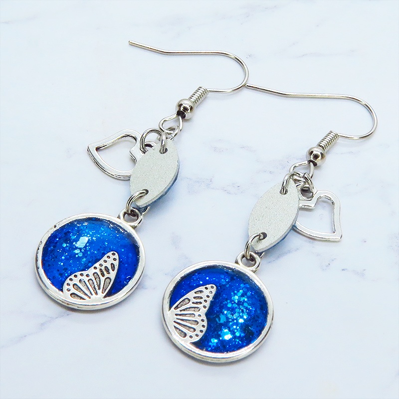 ブルーレジンで彩色した蝶の羽とアクアマリンのスワロフスキーのピアス オープンハート サージカル可