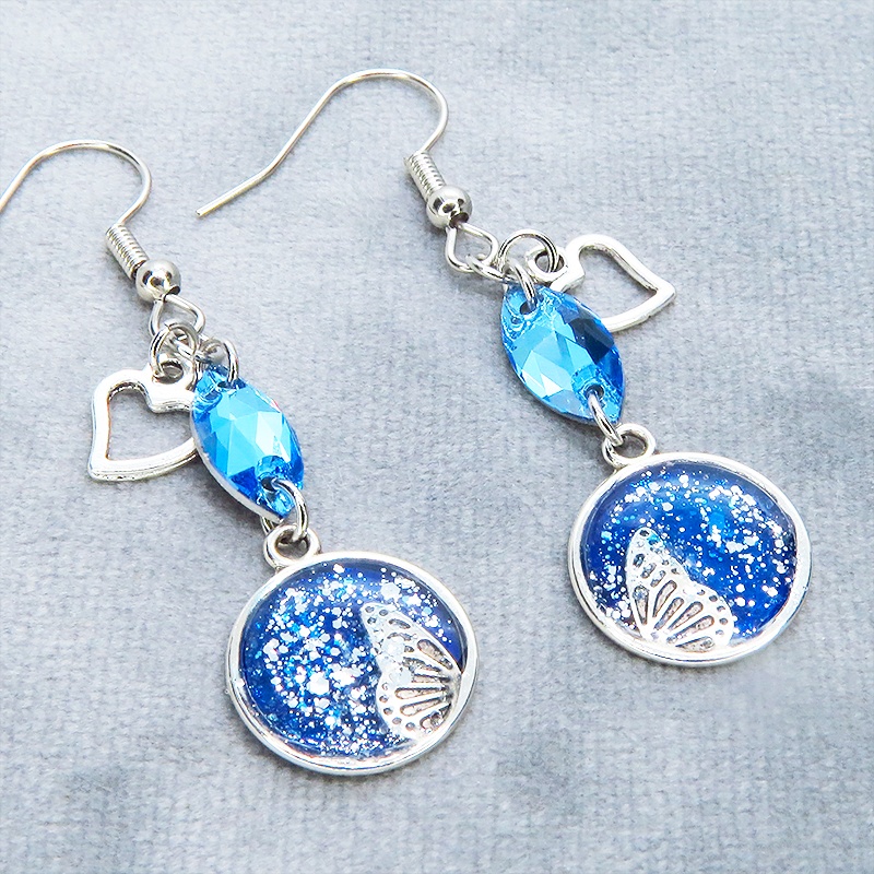 ブルーレジンで彩色した蝶の羽とアクアマリンのスワロフスキーのピアス オープンハート サージカル可