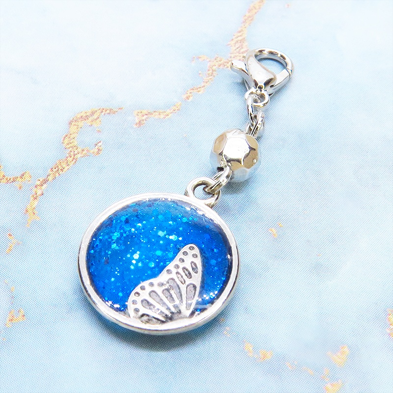 マスク・スマホチャーム ブルーレジンで彩色した蝶の羽と小さな花モチーフのチャーム 金具変更可