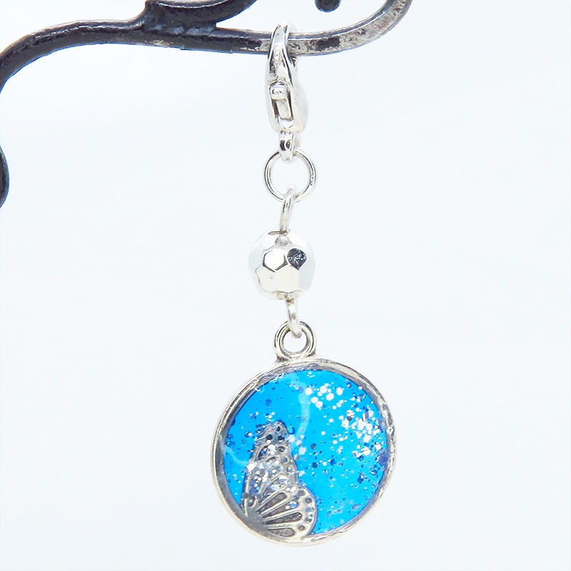 マスク・スマホチャーム ブルーレジンで彩色した蝶の羽と小さな花モチーフのチャーム 金具変更可