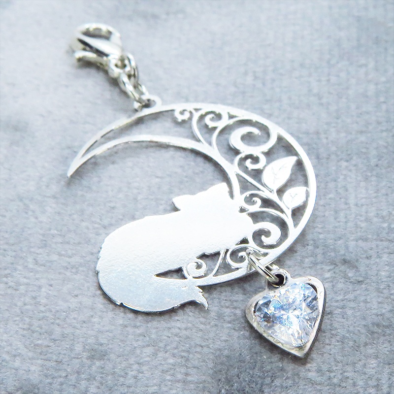 マスク・スマホチャーム シルバーカラー 三日月でくつろぐ猫モチーフとハート型スワロフスキーのチャーム 金具変更可