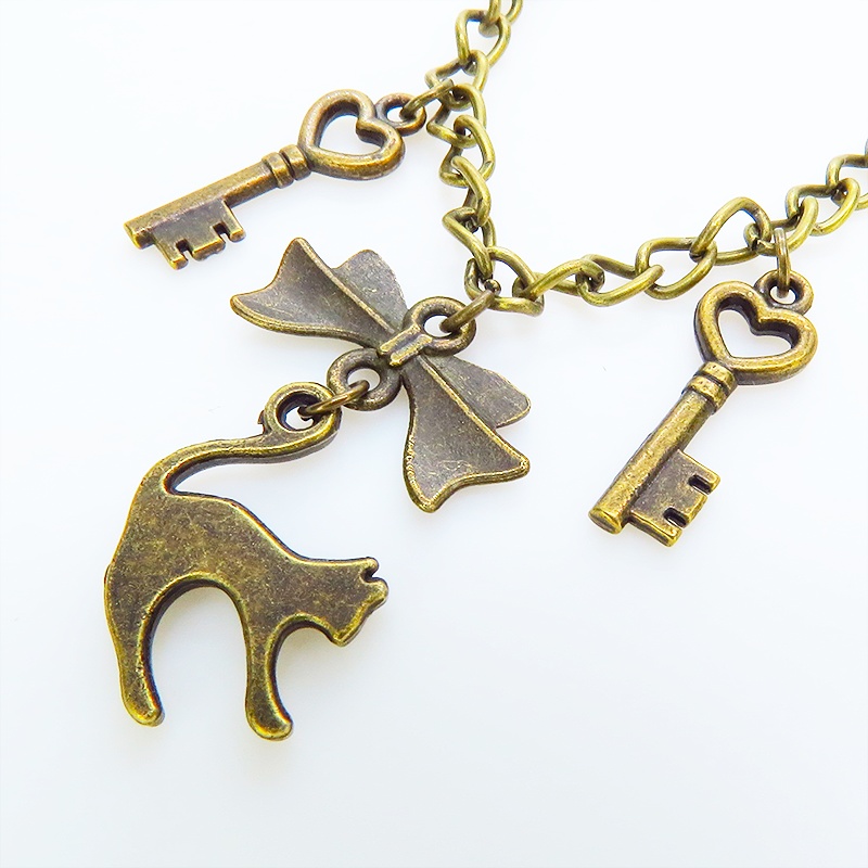 アンティークゴールド 跳ね猫シルエットモチーフとリボンに鍵が連なる大人可愛いブレスレット