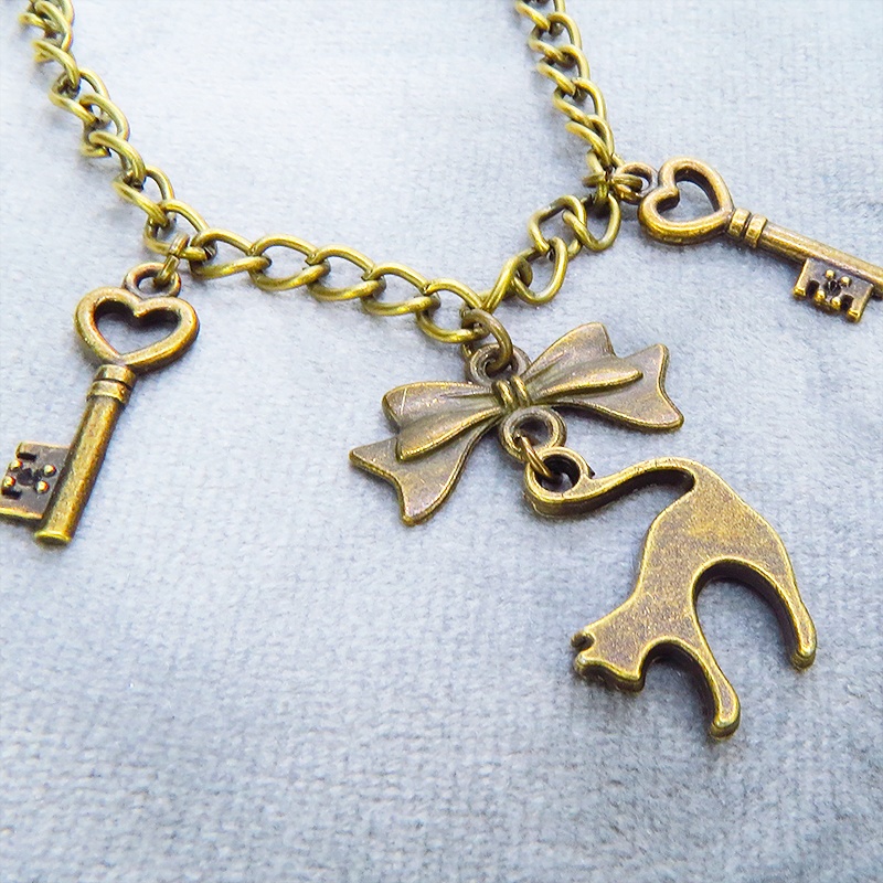 アンティークゴールド 跳ね猫シルエットモチーフとリボンに鍵が連なる大人可愛いブレスレット