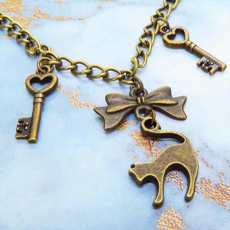 アンティークゴールド 跳ね猫シルエットモチーフとリボンに鍵が連なる大人可愛いブレスレット