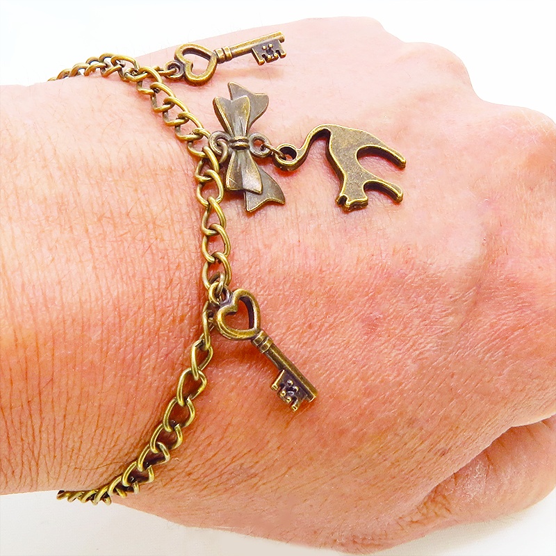 アンティークゴールド 跳ね猫シルエットモチーフとリボンに鍵が連なる大人可愛いブレスレット