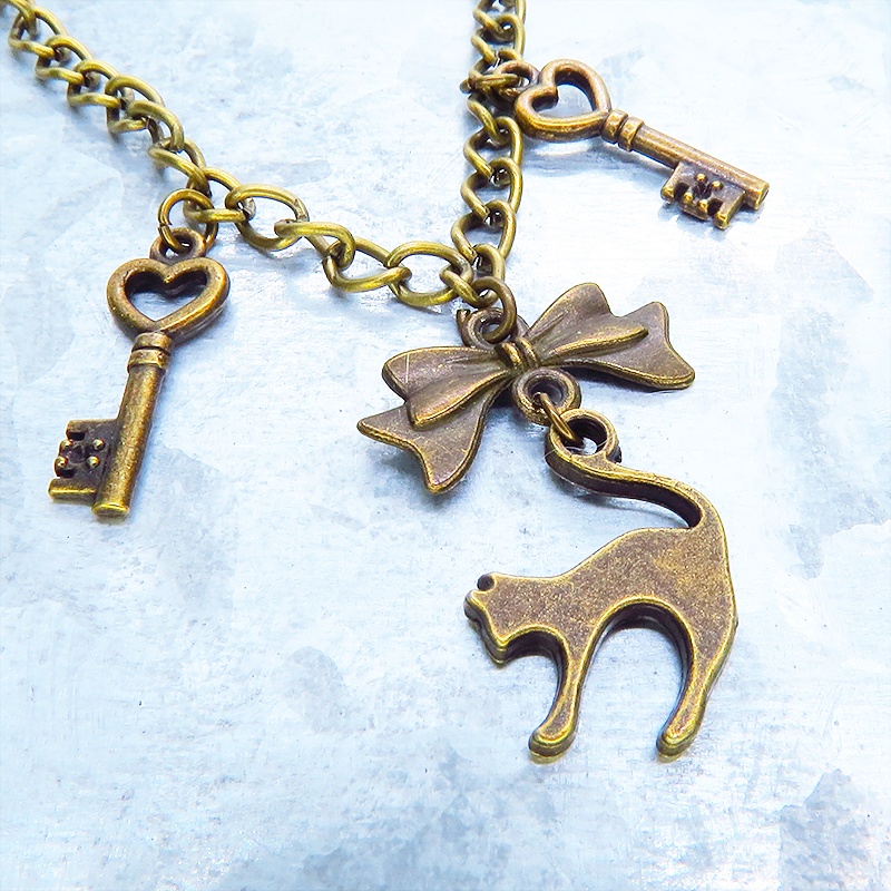 アンティークゴールド 跳ね猫シルエットモチーフとリボンに鍵が連なる大人可愛いブレスレット