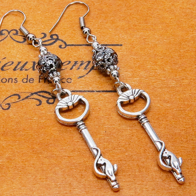 アンティークシルバー 猫が座る鍵モチーフのロングピアス ブラックメタルビーズ ラインストーン サージカル可
