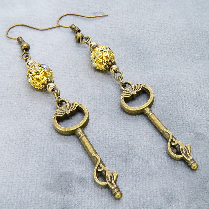 アンティークゴールド 猫が座る鍵モチーフのロングピアス ゴールドメタルビーズ ラインストーン