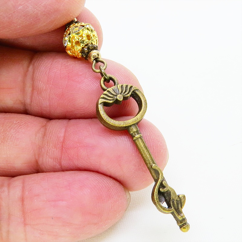 アンティークゴールド 猫が座る鍵モチーフのロングピアス ゴールドメタルビーズ ラインストーン