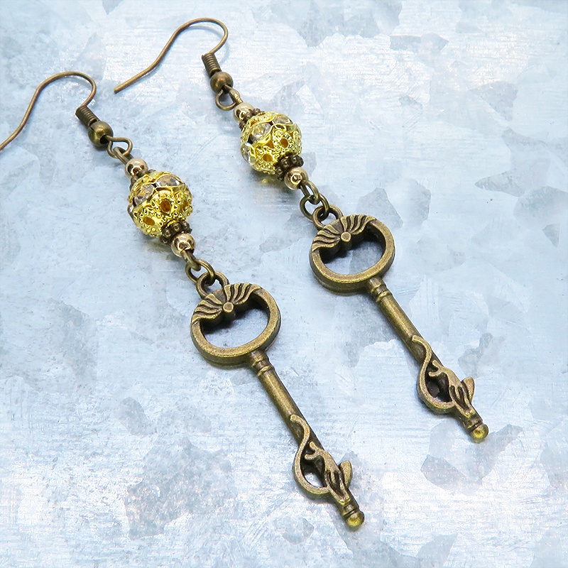 アンティークゴールド 猫が座る鍵モチーフのロングピアス ゴールドメタルビーズ ラインストーン