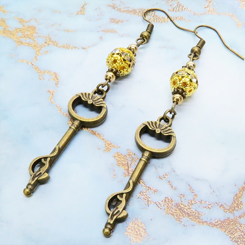 アンティークゴールド 猫が座る鍵モチーフのロングピアス ゴールドメタルビーズ ラインストーン