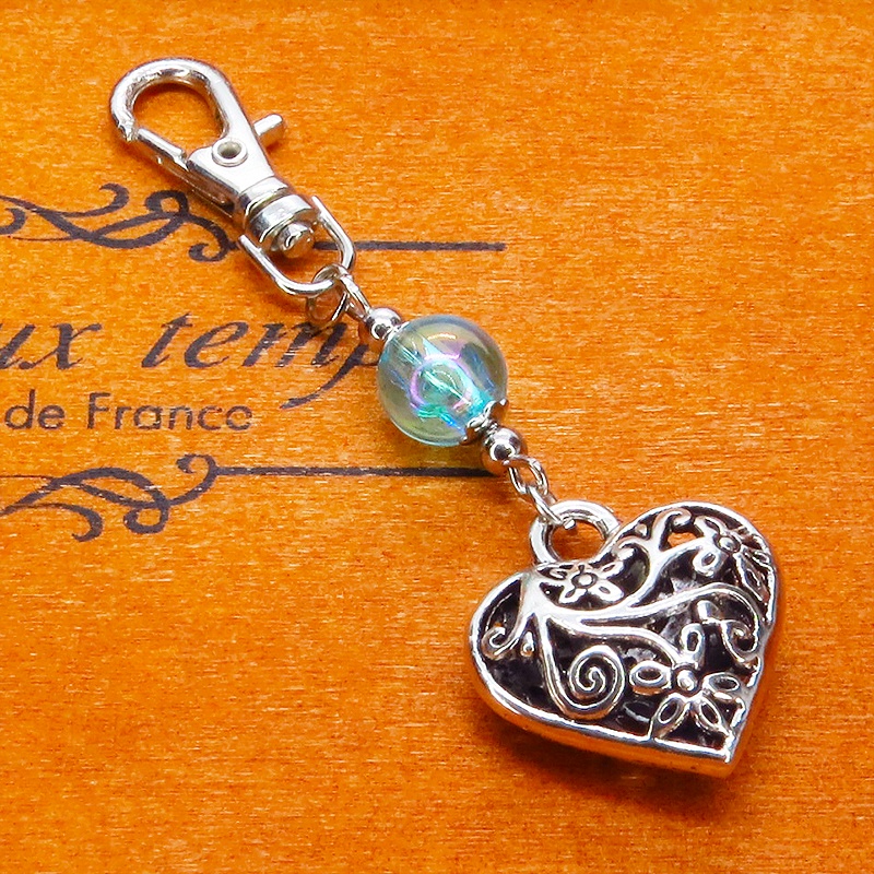 シルバーカラー アラベスク調の透かし模様のハートとクリアブルーのビーズのキーホルダー 金具変更可