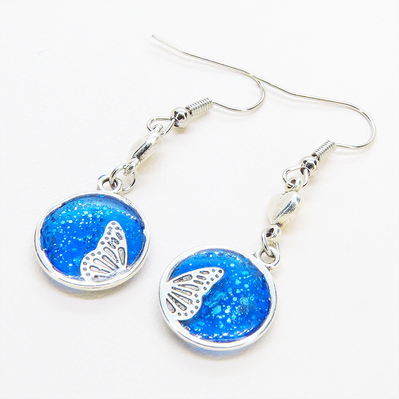 シルバーカラー ブルーレジンで彩色した蝶の羽と小さなハートのピアス サージカル可