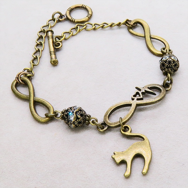 アンティークゴールド 跳ね猫モチーフのブレスレット ラインストーンとエターナルモチーフのチェーン