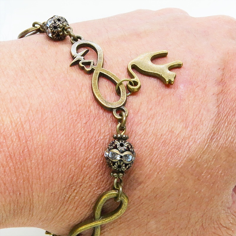 アンティークゴールド 跳ね猫モチーフのブレスレット ラインストーンとエターナルモチーフのチェーン