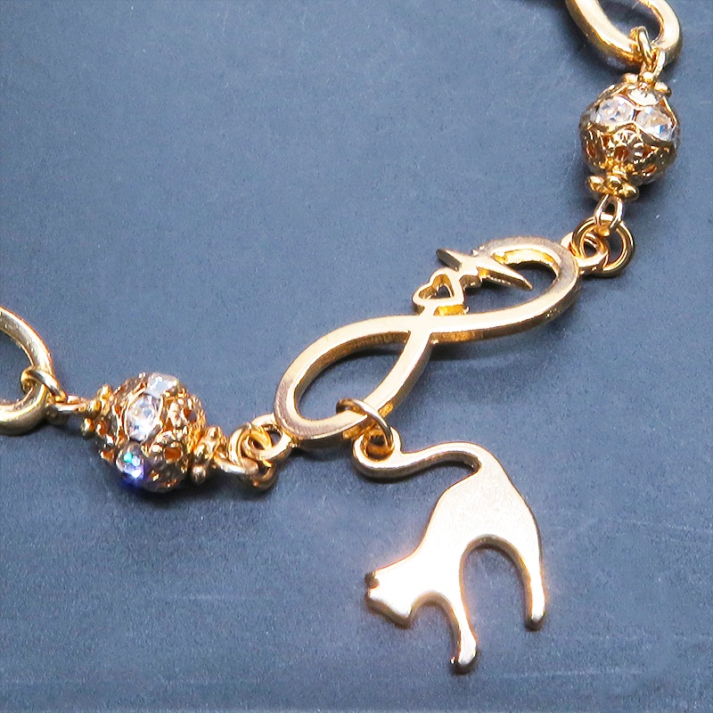 マットゴールド 跳ね猫モチーフのブレスレット ラインストーンとエターナルモチーフのチェーン